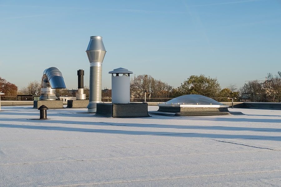 The top of a roof with silver power poles