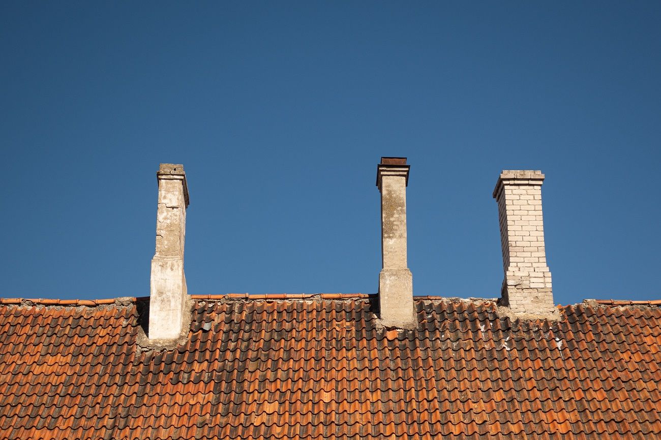 Close Up of Red Roof Tiles and Two Chimneys