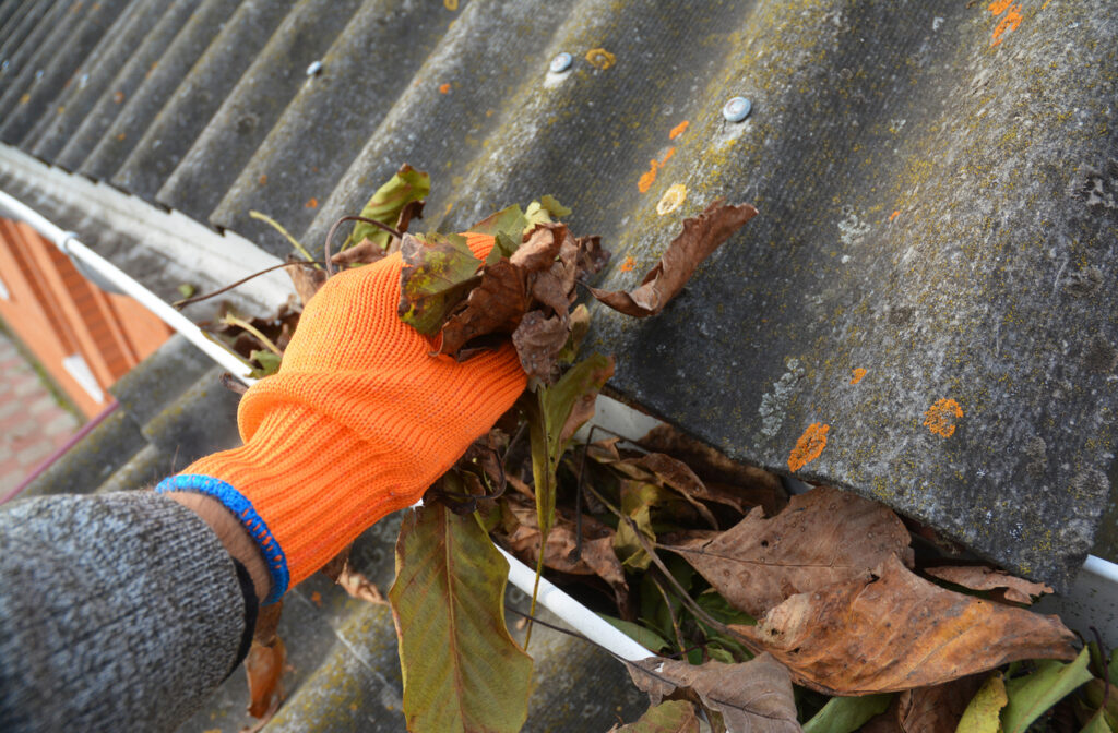 cleaning a blocked rain gutter